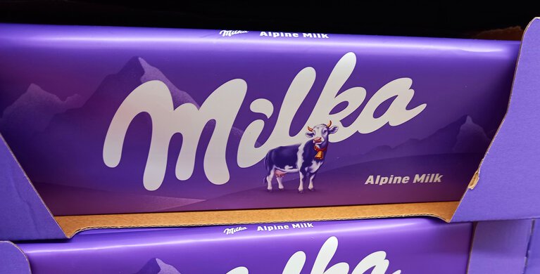Milka Schokolade in lila im Supermarktregal- zwei Schokoladentafeln nebeneinander  | © Foto: Magda Wygralak/Shutterstock.de