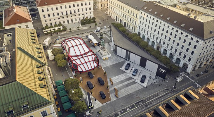 Foto vom IAA Space am Wittelsbacherplatz 2023 von oben mit riesiger Porsche Statue in weiß-rot