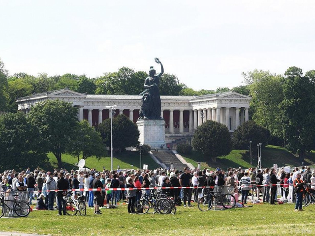 Teilnehmer einer Demonstrationen gegen die Anti-Corona-Maßnahmen der Politik stehen auf der Theresienwiese in München im abgesperrten Bereich. −Foto: dpa